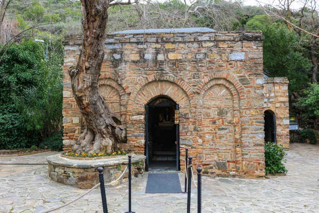 Stone structure of the House of the Virgin Mary in Ephesus, surrounded by lush greenery and historical ambiance.