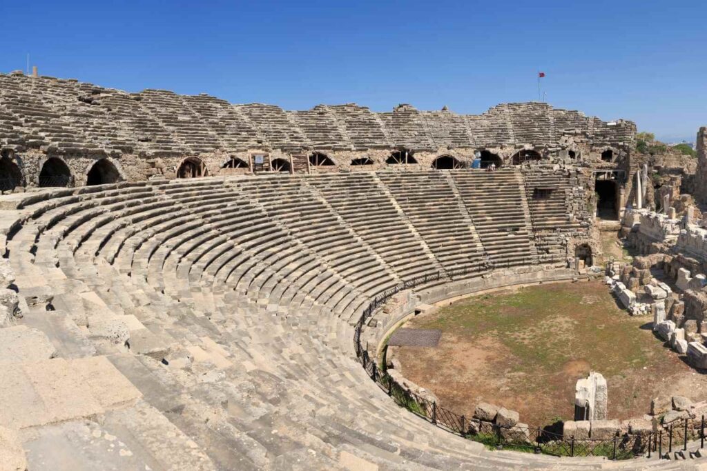 Side Ancient Theater in Turkey, featuring tiered stone seating and a central arena, showcasing ancient Roman architecture.